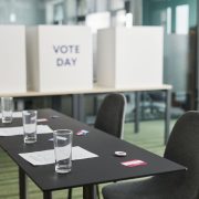 Seção eleitoral preparada em uma sala, com mesas, cadeiras e cabines de votação.