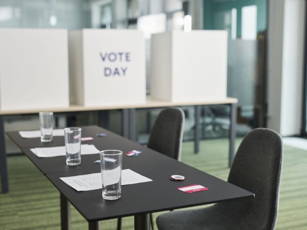 Seção eleitoral preparada em uma sala, com mesas, cadeiras e cabines de votação.