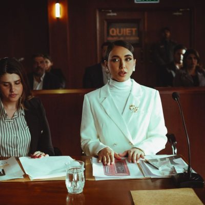 Duas advogadas analisam documentos em um ambiente semelhante a um tribunal.