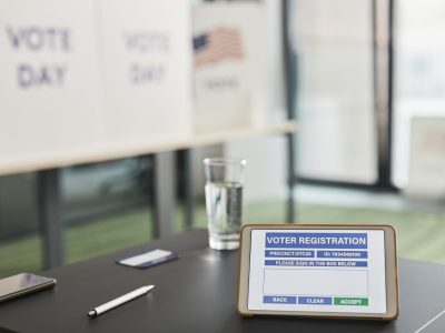 Tablet exibe uma tela de cadastro eleitoral digital em um local de votação.