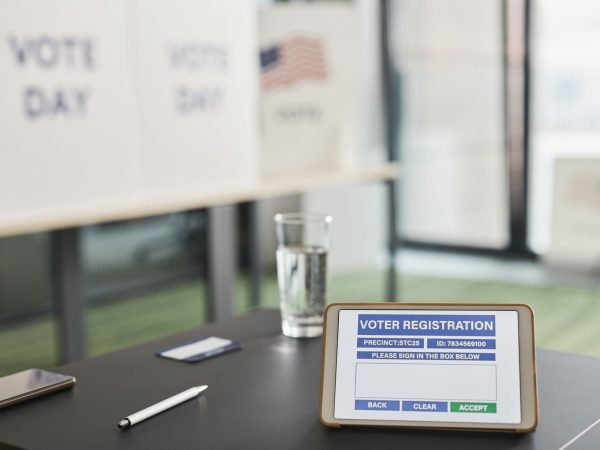 Tablet exibe uma tela de cadastro eleitoral digital em um local de votação.